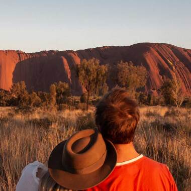 Couple looking at Uluru (Ayers Rock) located in the Red Centre, Northern Territory, Australia