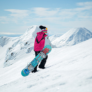 Snowboarder walking up the mountain