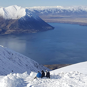 People sitting in the snow looking over the vista