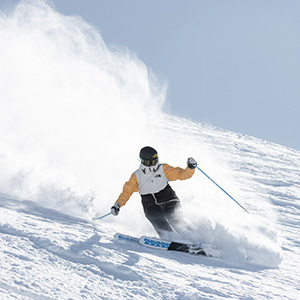 A skier slashes the powder snow up Treble Cone