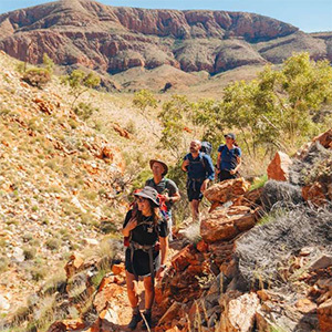 Group of hikers on a rocky desert trail.