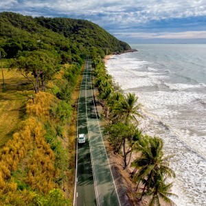 A car travelling along a coastal road in far North Queensland, Australia