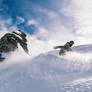 Snow Boarder slashes through the snow up Coronet Peak