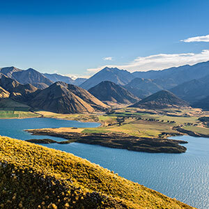 A landscape view of Lake Wanaka with the Mountain skyline contrasting the blue water