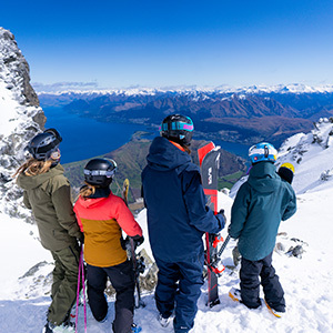 A group of four overlook the scenes from a look out point at the Remarkables